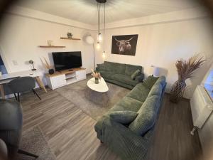 a living room with a green couch and a tv at Sweet Sleep Apartment in Burg Stargard