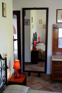 a bedroom with a mirror and a bed and a lamp at Corolle2 in Montepulciano
