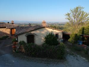 a small white building with a tower on top of it at Corolle2 in Montepulciano