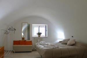 a white bedroom with a bed and a window at A Casa Di Giulia - Appartamento sul Lungomare - Giovinazzo in Giovinazzo