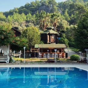 a resort with a house and a swimming pool at arzum bungalovs in Kumluca