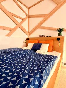 a blue and white bed in a room with wooden ceilings at LelleBay in Balatonlelle
