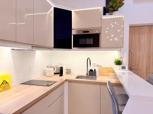 a kitchen with white cabinets and a sink at LelleBay in Balatonlelle +13 photos