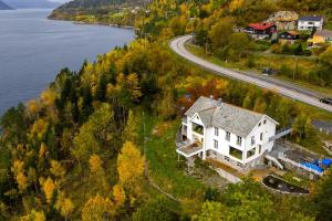 an aerial view of a house on a hill next to the water at Seaside apartment in Volda