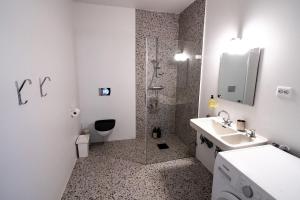 a white bathroom with a shower and a sink at Seaside apartment in Volda +17 photos