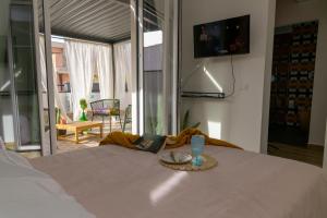 ein Zimmer mit einem Bett und einem Tisch, auf dem ein Getränk steht in der Unterkunft Curò in Cinisi