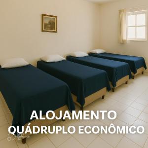 a room with three beds with blue sheets at Alojamento Pousada Economica Canoas in Canoas +3 photos