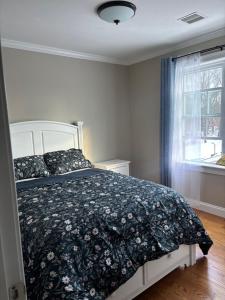 a bedroom with a bed with a black and white comforter at 12Birchwood in Holbrook