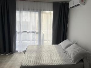 a bed in a bedroom with a large window at Depto temporal in Morón