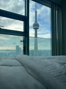 a bedroom with a bed and a view of auckland tower at Luxury Cityscape Condo in Toronto +9 photos