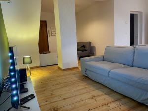 a living room with a blue couch and a television at Esprit Gare in Haubourdin