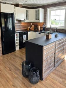 a kitchen with a black refrigerator and two baskets at Mountain Cabin With Jacuzzi In Gautefall in Drangedal
