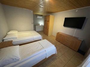a hotel room with two beds and a flat screen tv at okuninkanoclegi in Okuninka