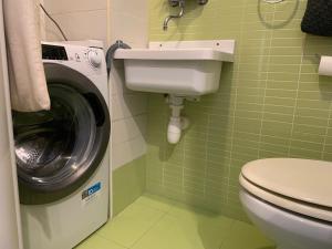a bathroom with a toilet and a washing machine at Vespro 1 Apartment - near the Greek theater in Syracuse +32 photos
