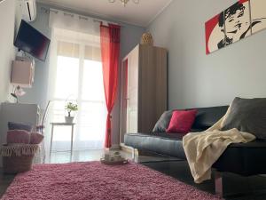 a living room with a couch and a pink rug at Vespro 1 Apartment - near the Greek theater in Syracuse