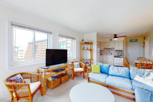 a living room with a blue couch and a tv at ABSW163 Southwinds H13 in Atlantic Beach