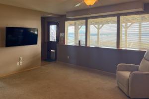a living room with a couch and a flat screen tv at The Sunrise Hideout in Port Ludlow