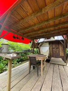 a wooden deck with a table and a red umbrella at Salvaje trip in Nuquí