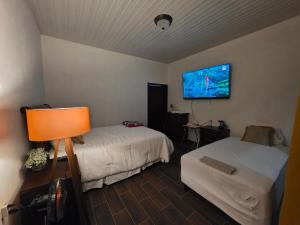 a room with two beds and a flat screen tv at Luana's 0601 in Choluteca +18 photos