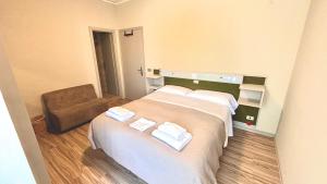 ein Hotelzimmer mit zwei Betten und Handtüchern darauf in der Unterkunft Umbria Green Central Rooms in Castiglione del Lago