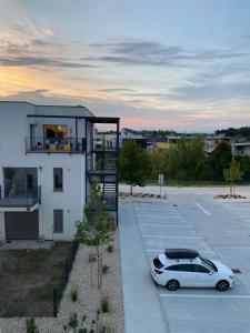 a white car parked in a parking lot next to a building at Apartment Nina in Hrubá Borša
