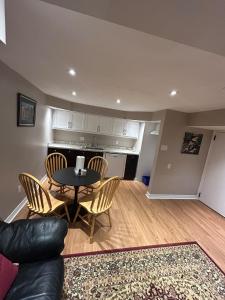 a living room with a table and chairs and a kitchen at 2 Bedroom 1 Bathroom Basement Suite in Toronto