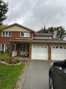 a house with two garage doors and a car parked at 2 Bedroom 1 Bathroom Basement Suite in Toronto