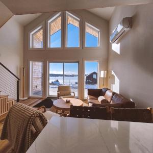 a living room with a couch and a table at Modern Nordic Cabin 2 Hot Tub & Views in East LaHave