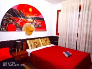 a bedroom with a red bed and a painting on the wall at Apartment in Villa Sea Horizon Sand Beach in Cefalù