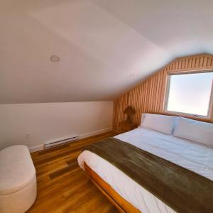 a bedroom with a large bed and a window at Modern Nordic Cabin 2 Hot Tub & Views in East LaHave
