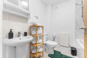 a white bathroom with a sink and a toilet at HomeBase Midlands Contractors Relocation Parking in Walsall