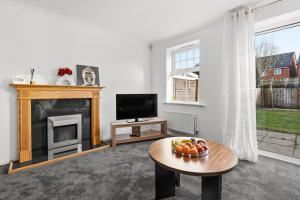 a living room with a fireplace and a television at HomeBase Midlands Contractors Relocation Parking in Walsall