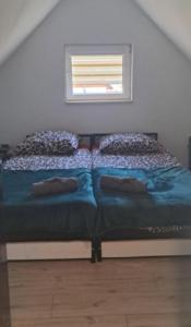a bed in a room with a window and two pillows at Niesamowita Dolina in Zdonia