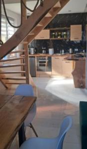 a kitchen with a wooden table and blue chairs at Niesamowita Dolina in Zdonia