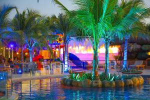 a pool with palm trees in a theme park at Laguna Beach Ecohotel in Tolú