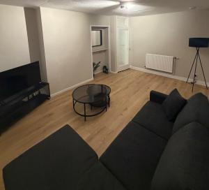 a living room with a couch and a glass table at Spacious 2 bed apartment with private parking space in Edinburgh