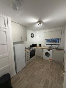 a kitchen with white cabinets and a washer and dryer at Spacious 2 bed apartment with private parking space in Edinburgh