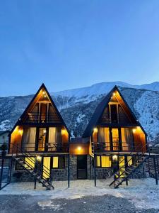 a log cabin with snow covered mountains in the background at Sno loveland in Sno