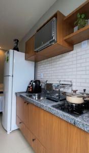 a kitchen with a stove and a white refrigerator at Villa Safira Residence in Caxias das Aldeias Altas