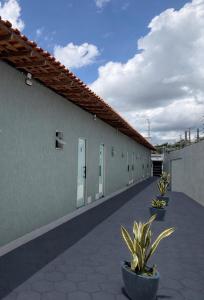 a building with a row of doors and potted plants at Villa Safira Residence in Caxias das Aldeias Altas