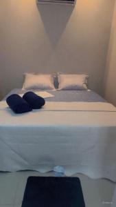a large white bed with two pillows on it at Villa Safira Residence in Caxias das Aldeias Altas
