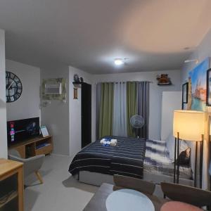 a bedroom with a bed and a living room at Comfy WalkUp Studio Near Mactan Airport -Perfect for Travellers in Lapu Lapu City