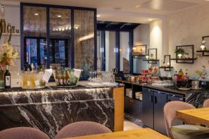 a bar in a restaurant with a counter and chairs at Hôtel des Arts Montmartre in Paris