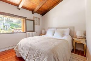 a bedroom with a large white bed with a window at Golindo Goikoa in Getaria