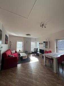 a living room with a red couch and a table at Apartmány Na Rozcestí in Lomnice nad Popelkou