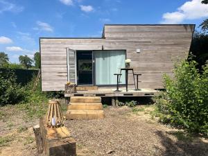 a small house with a porch and a bench at Le repère d Howardries in Brunehaut