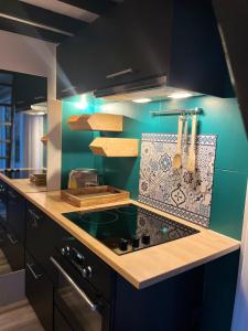 a kitchen with a stove and a blue wall at Le repère d Howardries in Brunehaut