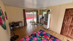 a living room with a table and a refrigerator at Hiti Village G4 in Tikehau Airport +3 photos