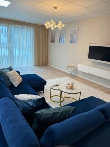 a living room with blue couches and a tv at City-Apartment Braunschweig in Braunschweig