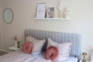 a bedroom with a bed with pink and white pillows at City-Apartment Braunschweig in Braunschweig